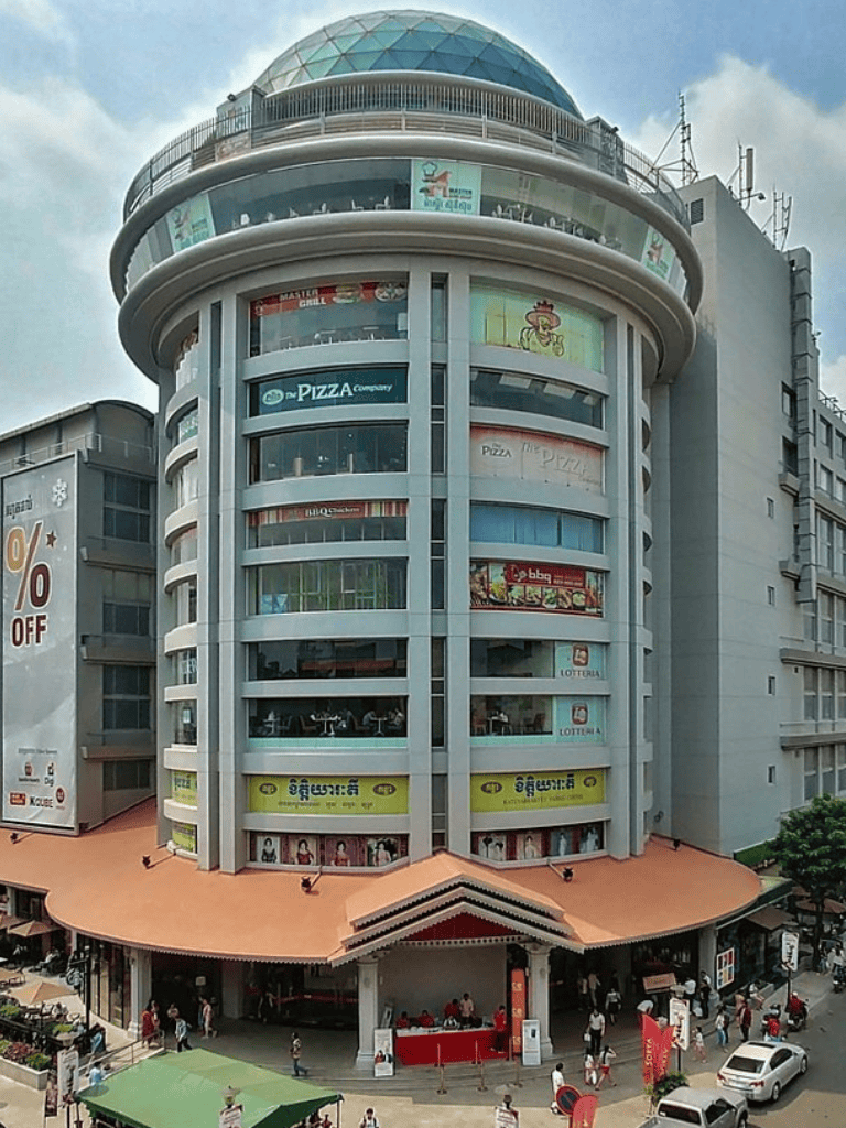 Bright multi-story commercial building with rounded design and glass dome rooftop in city center.