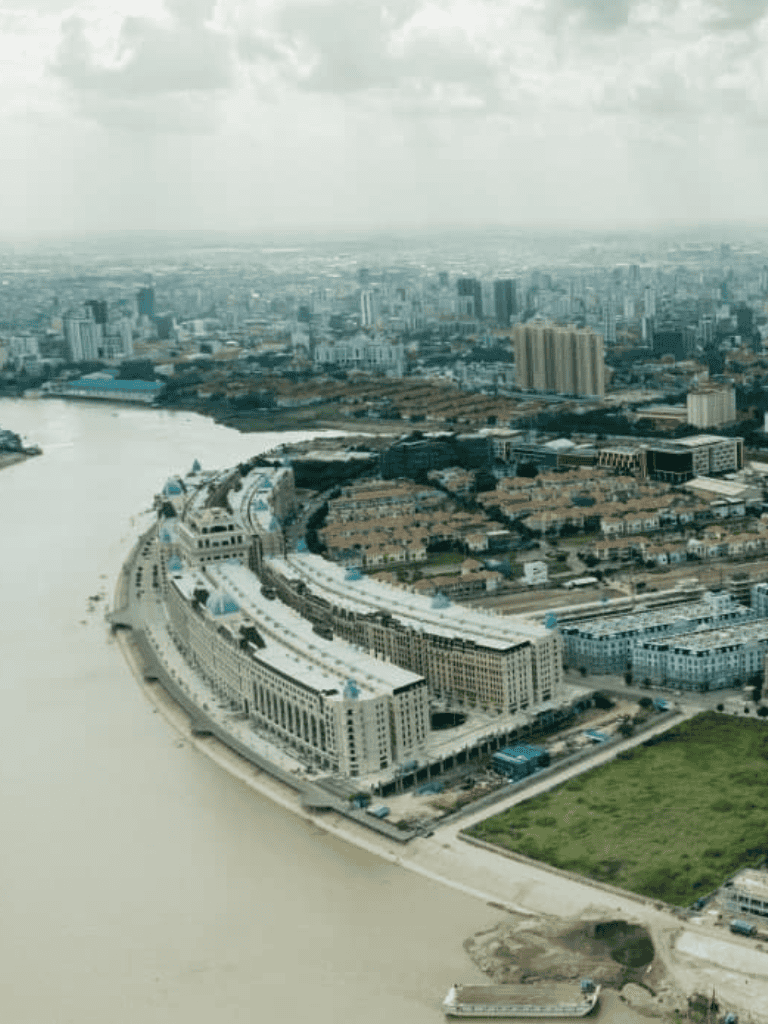 Modern cityscape with waterfront, high-rise buildings, and urban development, showcasing real estate opportunities.