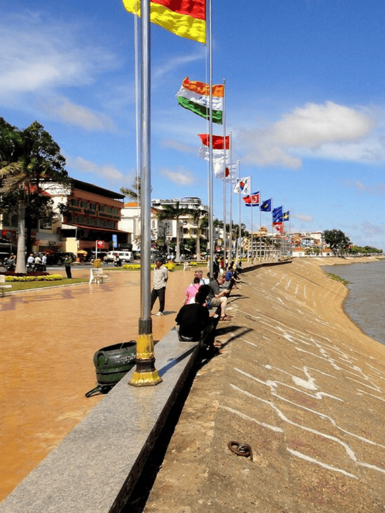 Colorful flags along the seafront promenade in a vibrant coastal city.