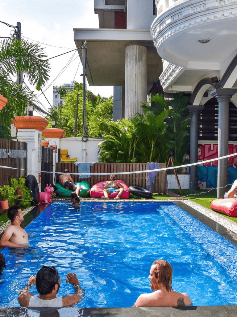 Relaxing backyard pool party with friends and colorful inflatables on a sunny day.
