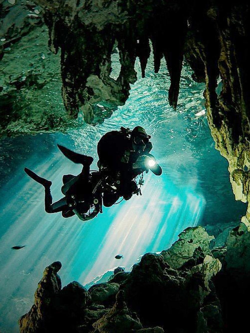 Underwater cave diving adventure with a scuba diver exploring a cavern for outdoor exploration.