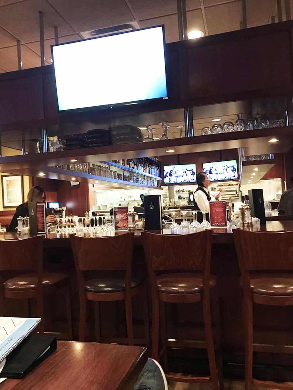 Modern bar with multiple television screens and wooden stools at QuestForDirections.