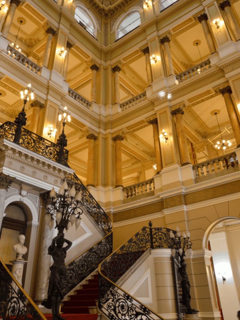 Elegant historic hotel interior with ornate staircases and classical decor.