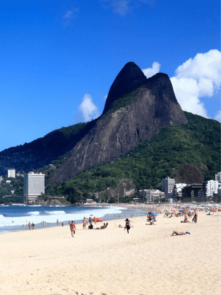 Vivid beach scene with Sugarloaf Mountain in Rio de Janeiro, Brazil, featuring clear blue sky and relaxing vacation atmosphere.
