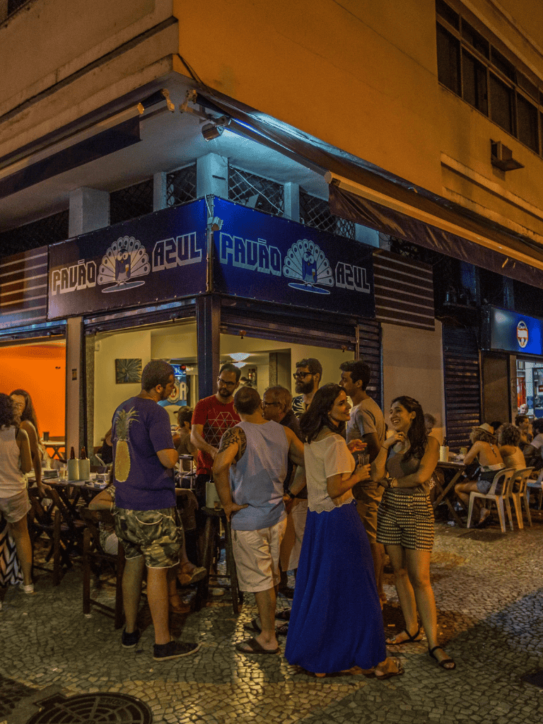 Vibrant nightlife scene at a popular outdoor restaurant in Brazil, lively crowd enjoying dinner and drinks at QuestForDirections.