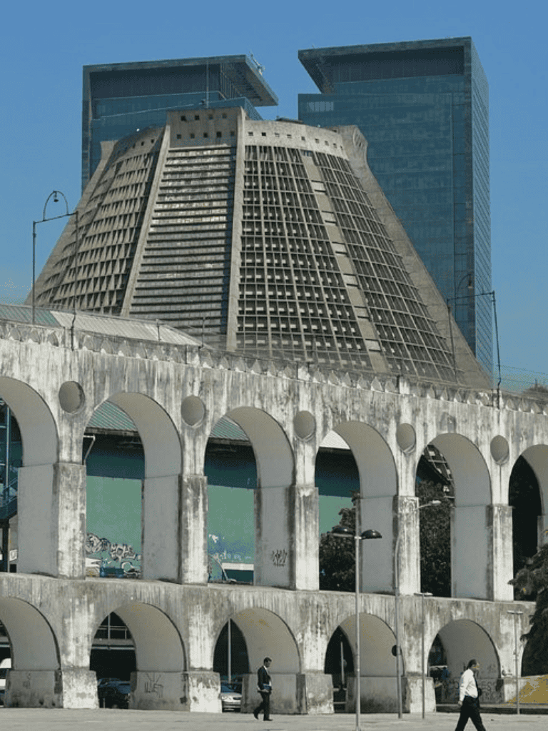 1. Modern office buildings near historic concrete arches in downtown cityscape.