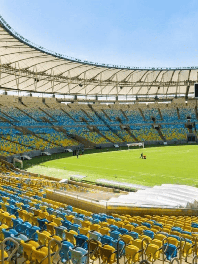 1. Modern stadium with colorful seating and bright green field for soccer or football games.