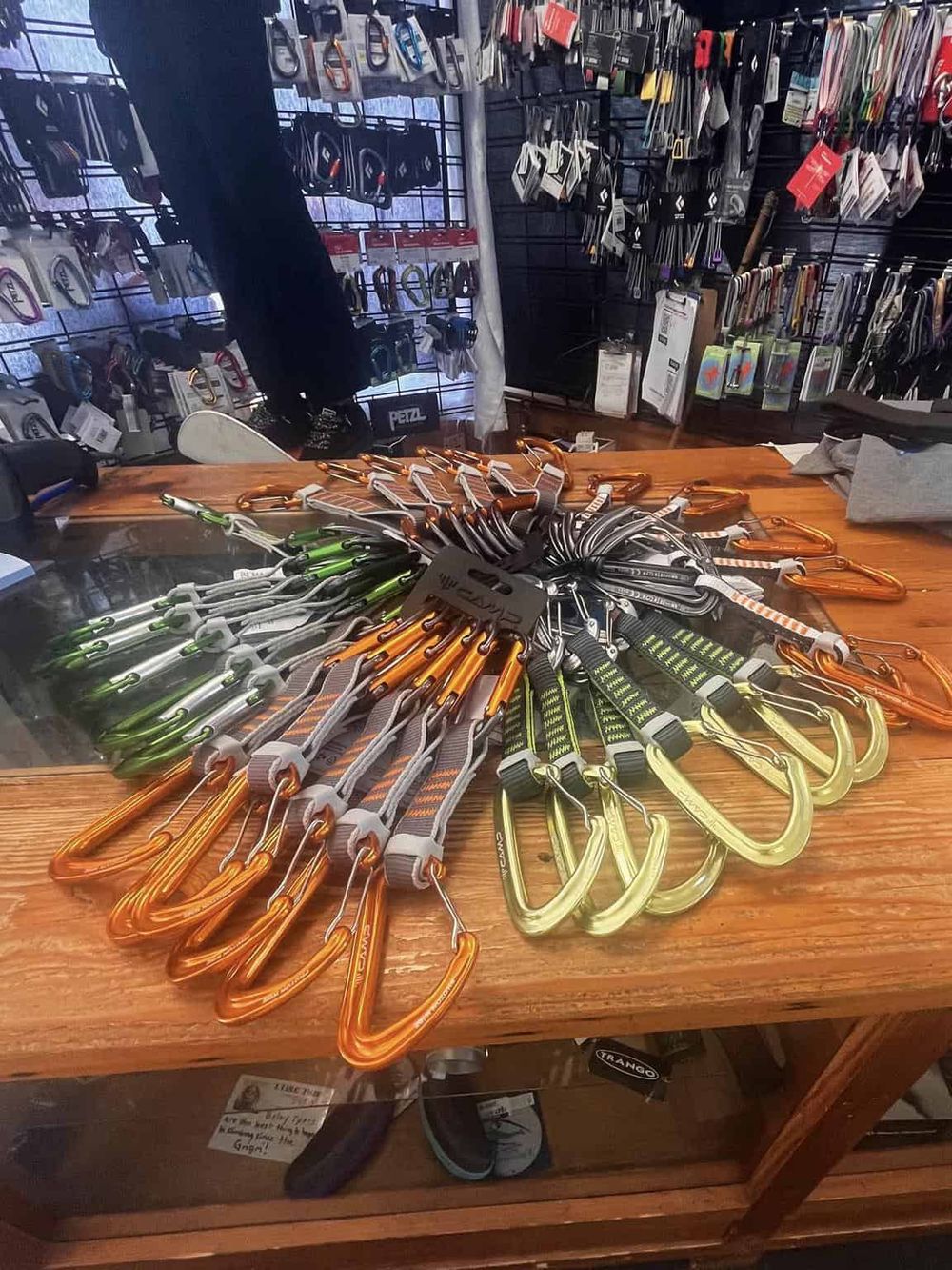 Colorful climbing carabiners and quickdraws on display at outdoor gear store.