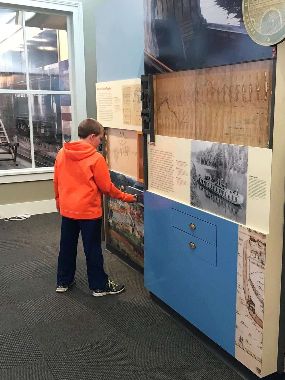 Exploring museum exhibits with historical maps and stories about transportation history.