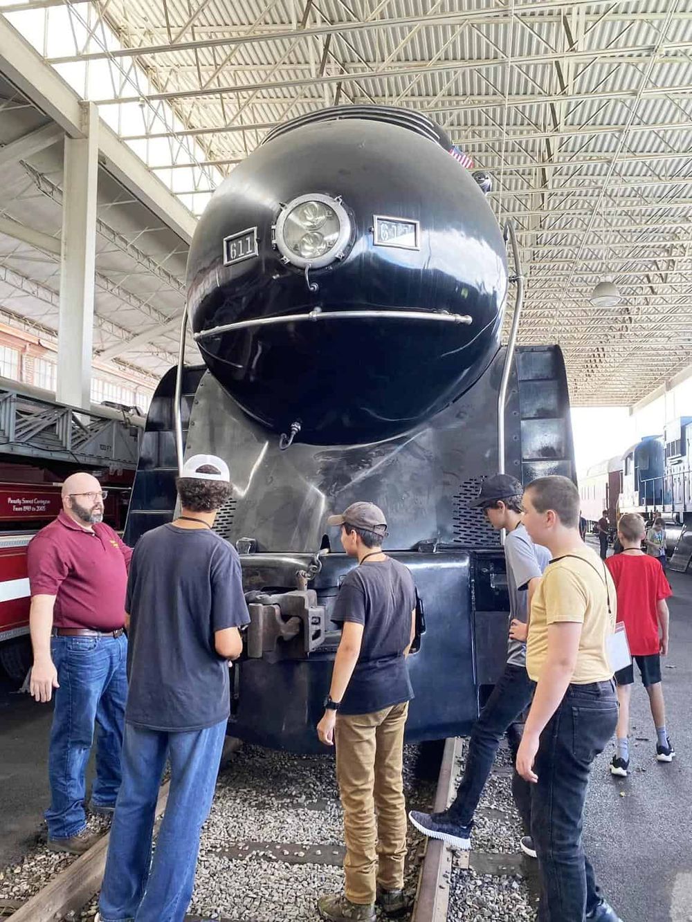 1. Large vintage steam locomotive at museum, visitors exploring historic train exhibits.