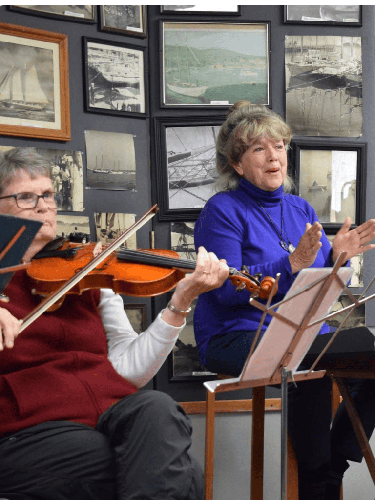 Violinists performing at QuestForDirections art gallery exhibit.