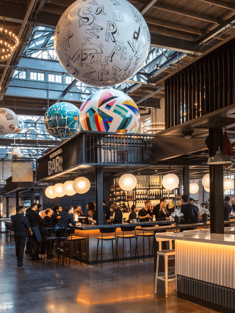 Colorful modern bar with large decorative hanging spheres and vibrant lighting at QuestForDirections restaurant.