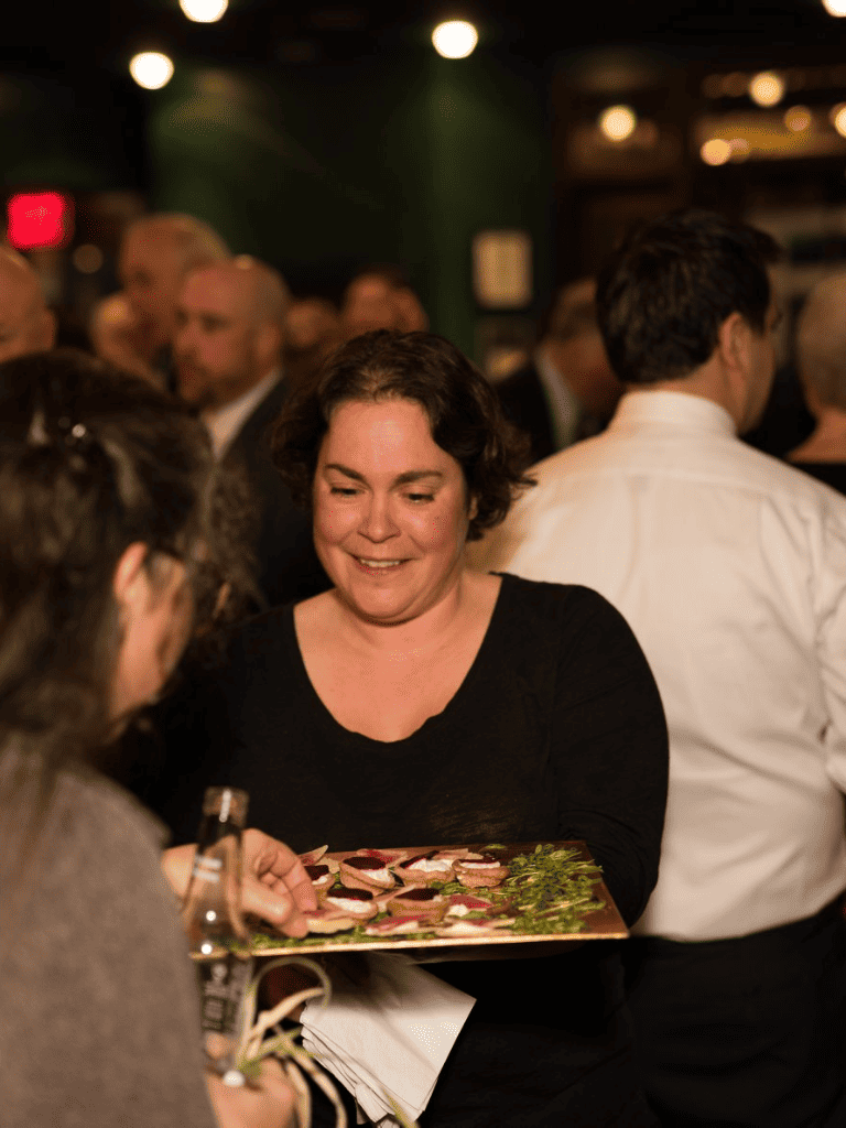Elegant woman serving appetizers at a networking event for QuestForDirections.
