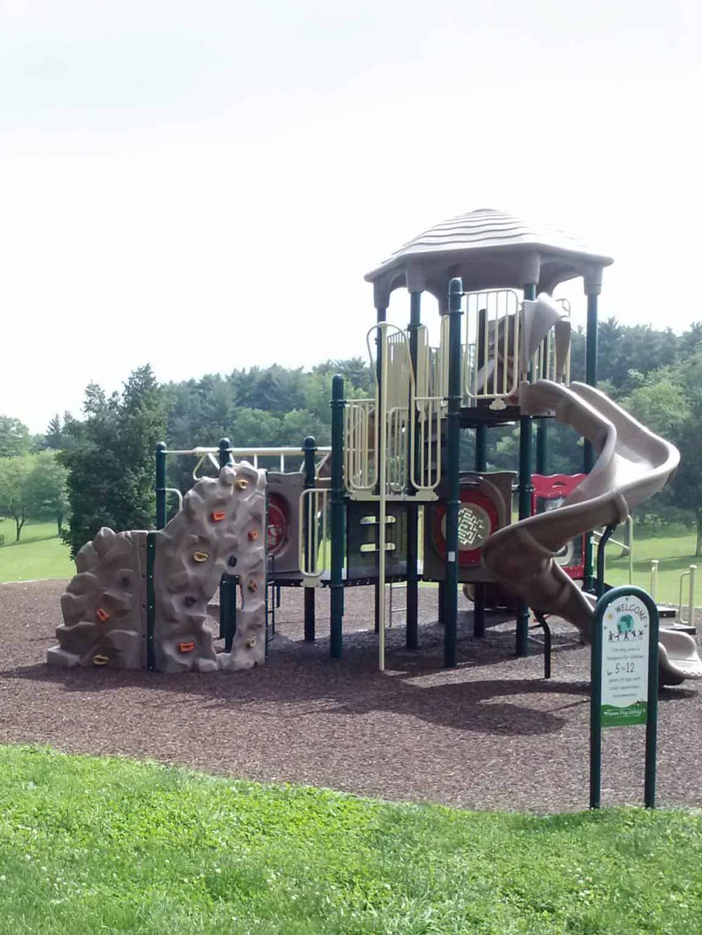 Colorful children’s playground with slides and climbing wall at QuestForDirections park.