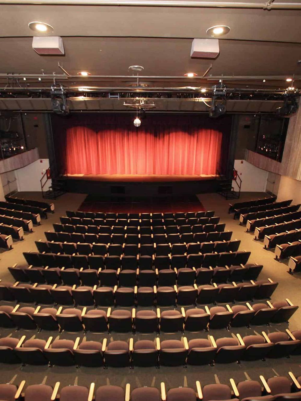 Modern theater interior with stage and seating, ideal for live performances and entertainment.