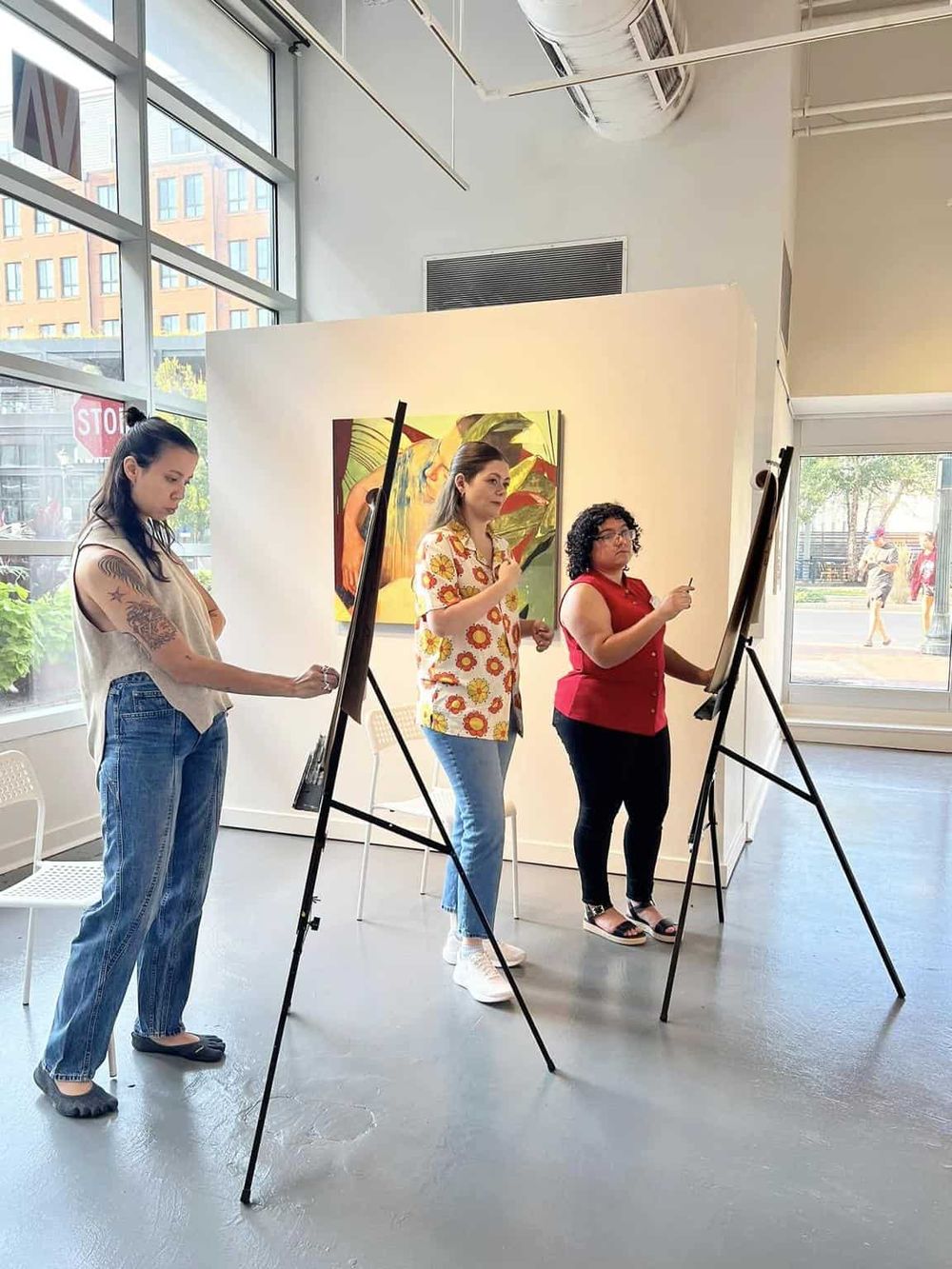 1. Women painting on easels in art gallery, diverse artistic community, creative painting session.