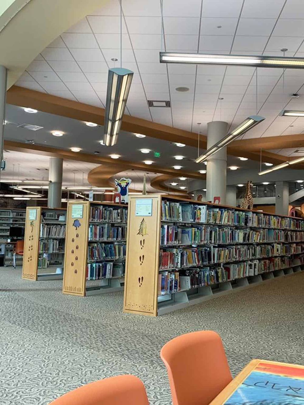 Brightly lit modern library interior with bookshelves and reading areas, perfect for studying and research.