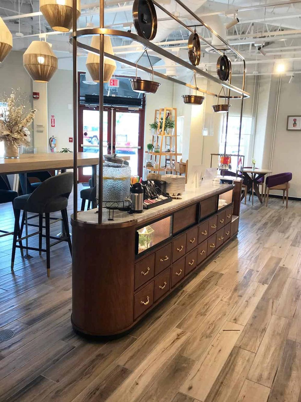 Cozy cafe interior with vintage wooden furniture, hanging pendant lights, and indoor plants, perfect for relaxing and enjoying coffee.