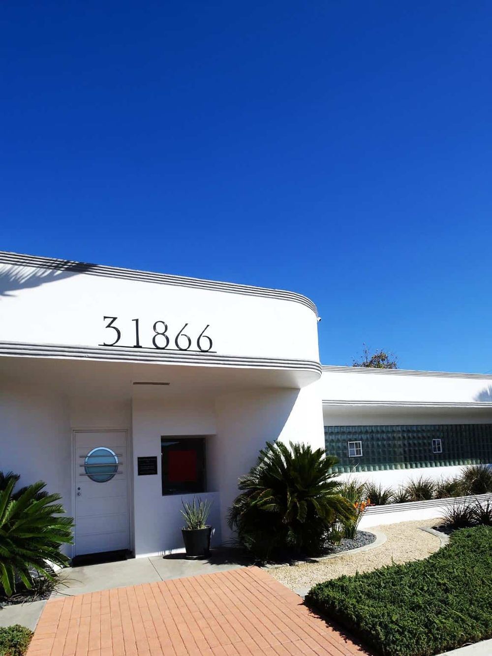 Contemporary building with modern architecture, address 31866, under clear blue sky.
