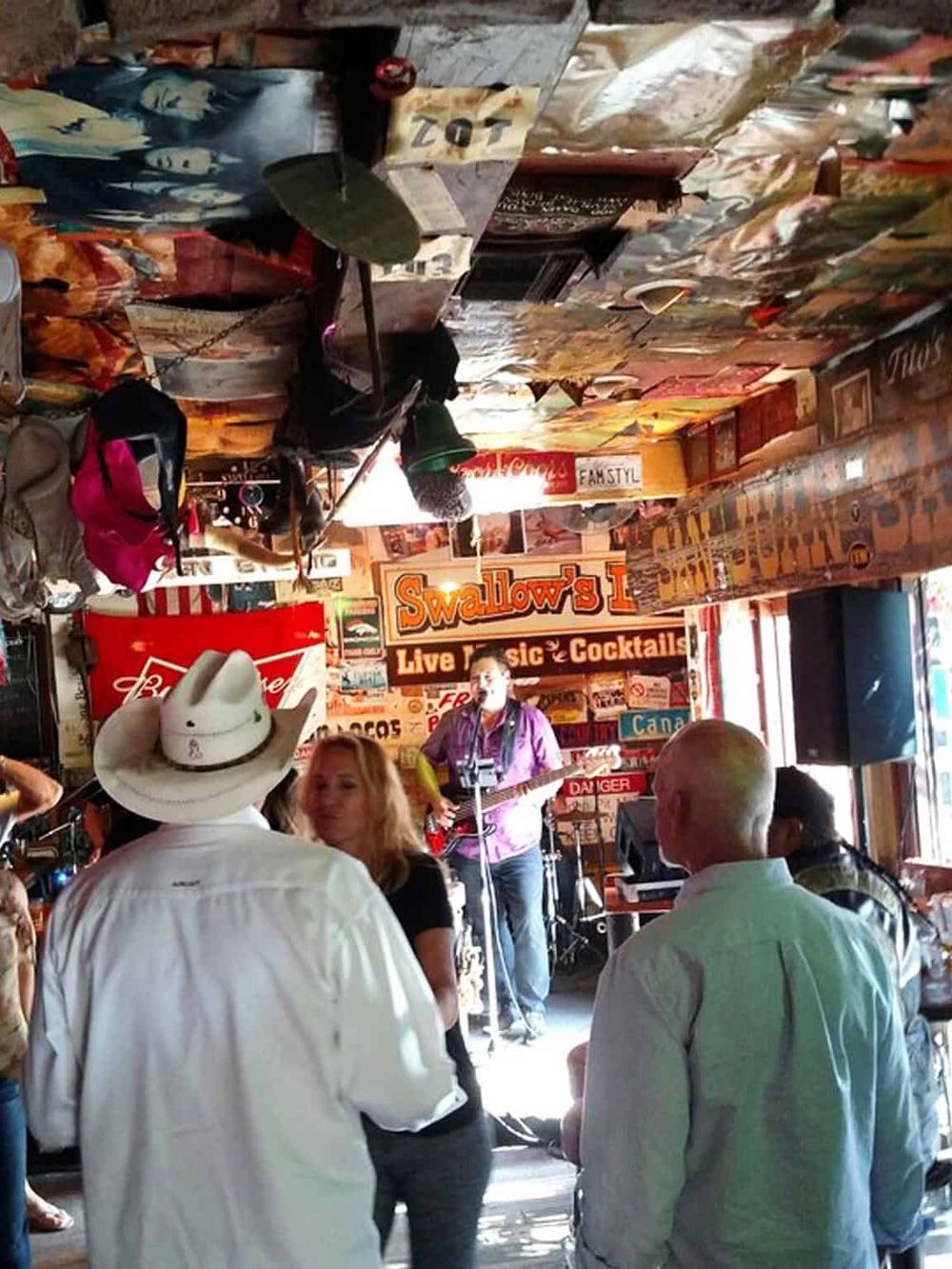 Live country music performance at a lively bar with colorful decor and an energetic crowd.