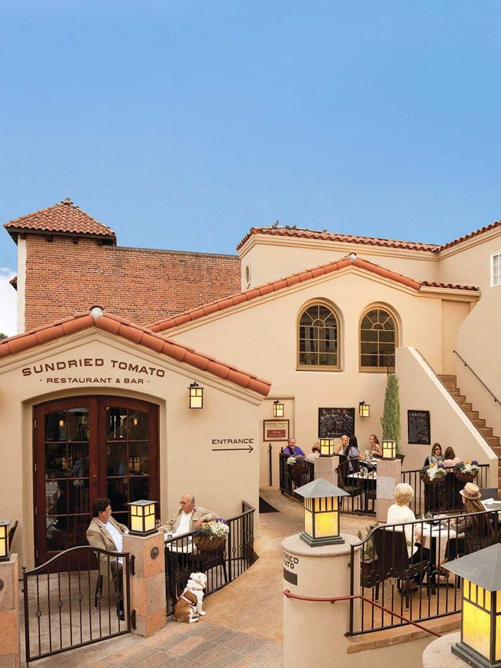 Charming outdoor dining at Sundried Tomato Restaurant & Bar with diners enjoying food on a sunny day.