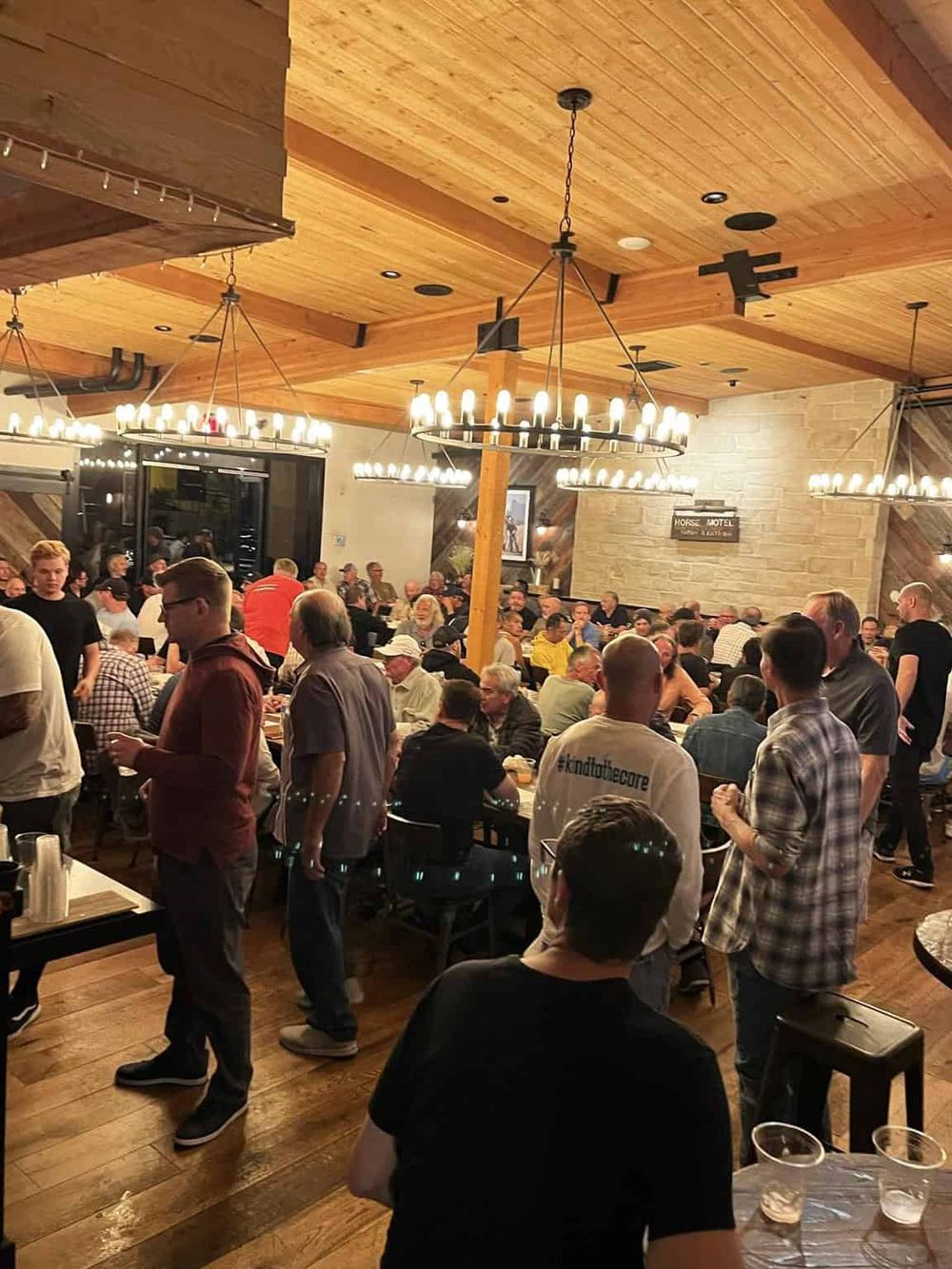 Vibrant indoor dining at Quest for Directions with a lively crowd and rustic decor. Perfect for social gatherings and events.