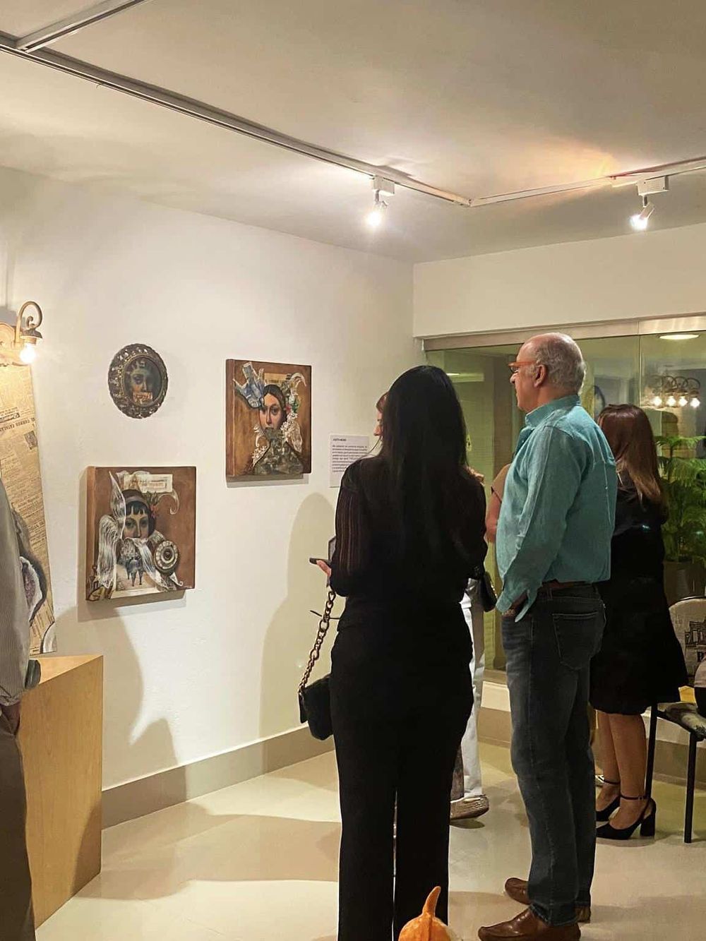 Colorful artwork displayed at an art gallery, with visitors engaging and appreciating the pieces.