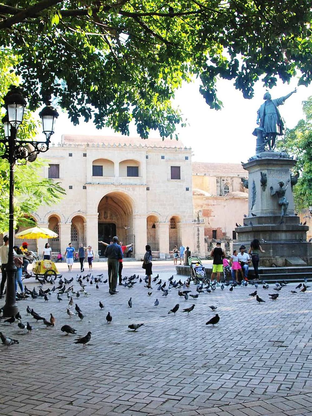 Historic plaza with pigeons, statue, and colonial architecture - explore QuestForDirections travel guide.