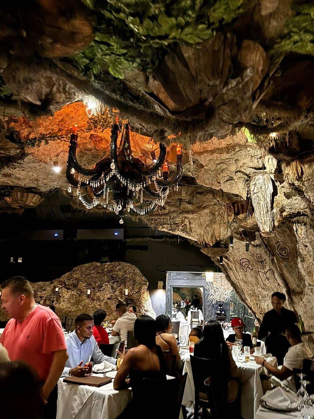 Chandelier hanging inside a cave restaurant showcasing unique dining experience and cave interior design.