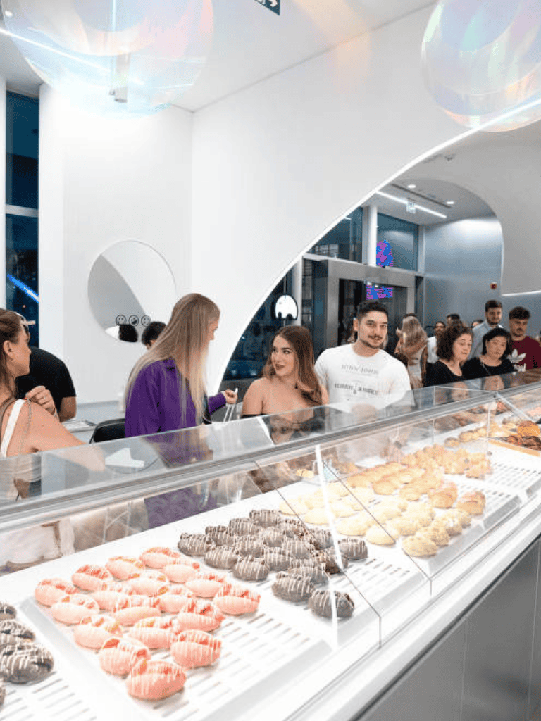 Delicious assorted cookies and pastries at a modern bakery with customers enjoying treats.