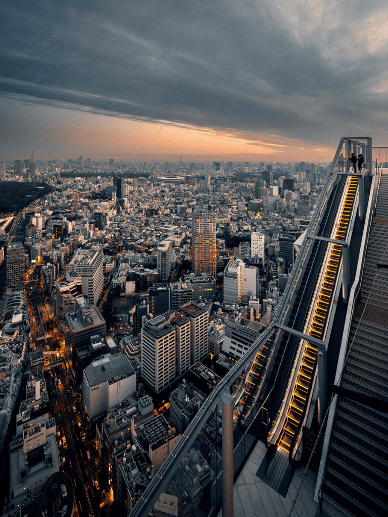 Panoramic view of city skyline from skyscraper rooftop at sunset, urban landscape, modern architecture, downtown, cityscape photography.