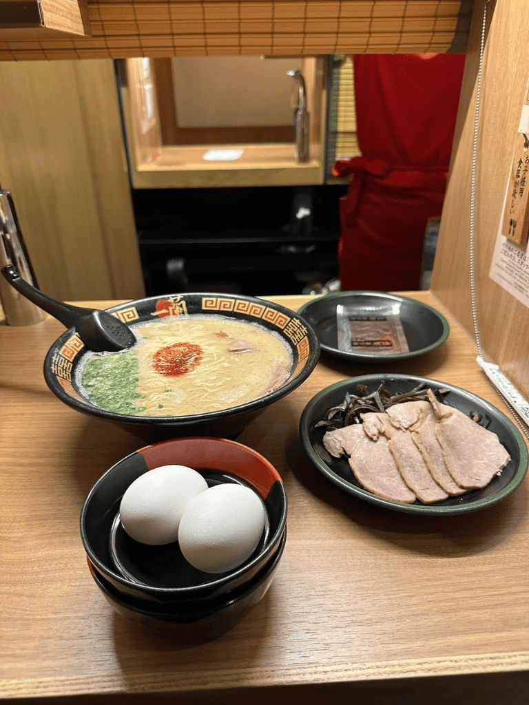 Steak and ramen meal with eggs, thinly sliced meat, and broth at Japanese restaurant.