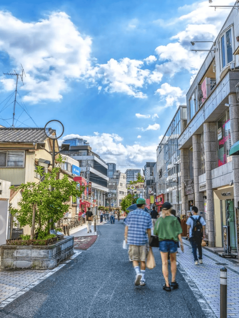 Bright urban street scene with pedestrians, modern buildings, and blue sky, illustrating city navigation and directions.