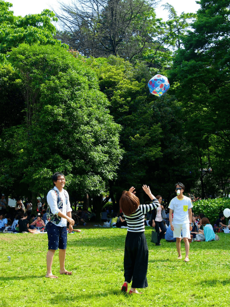 Floating lantern in a lush green park during daytime with people enjoying outdoor activities.