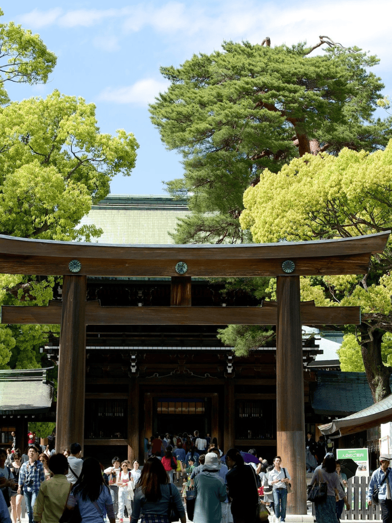 Large Torii Gate at a crowded traditional Japanese shrine during daytime – popular sightseeing spot.