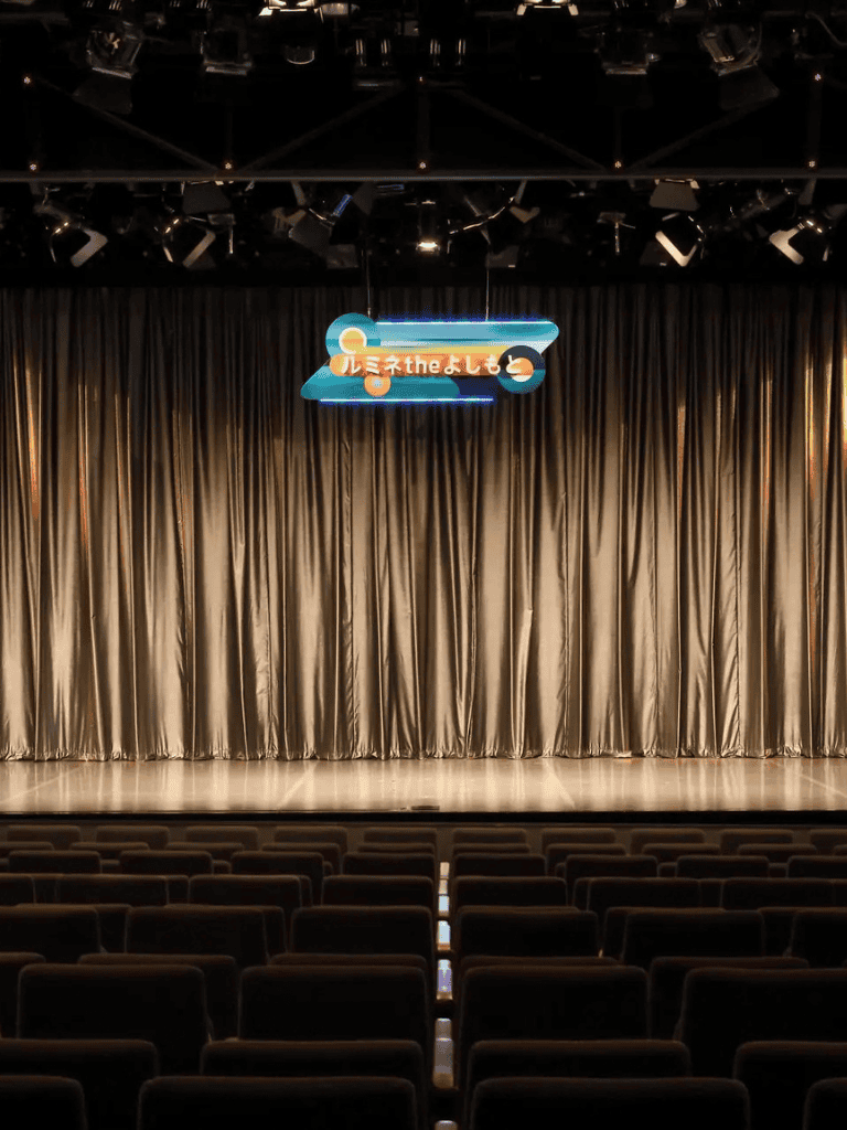 Bright stage with curtains and digital sign, ideal for performances at QuestForDirections.
