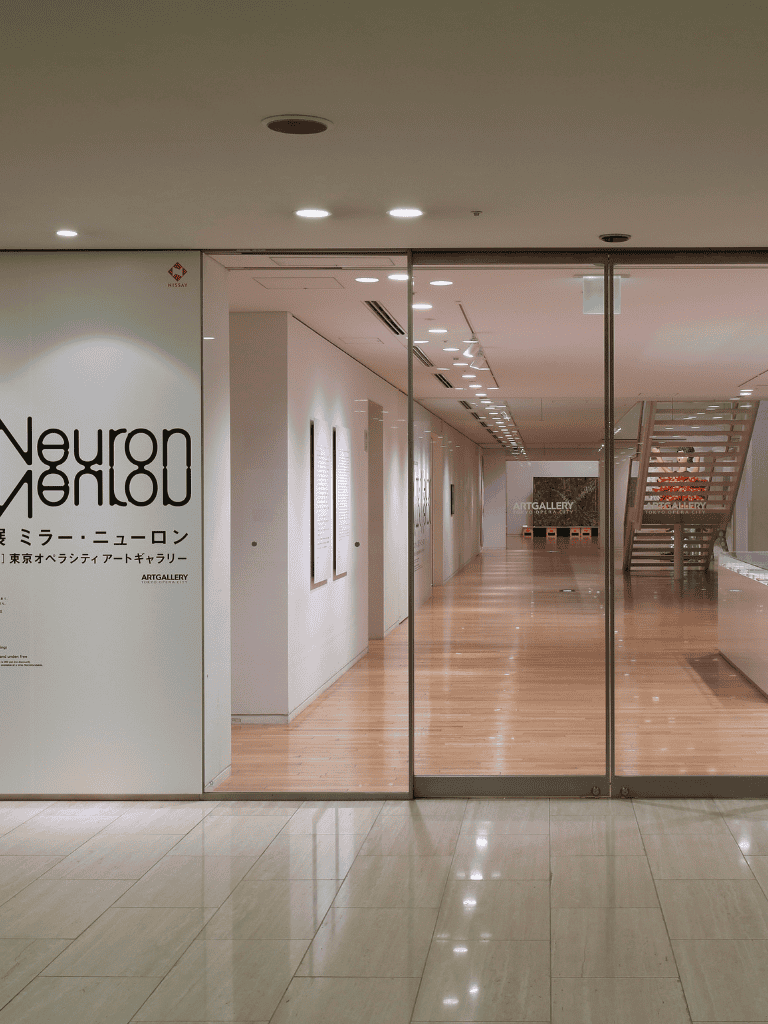 Neuron Mirror logo displayed at Tokyo Opera City Art Gallery, modern interior design, minimalist art space.