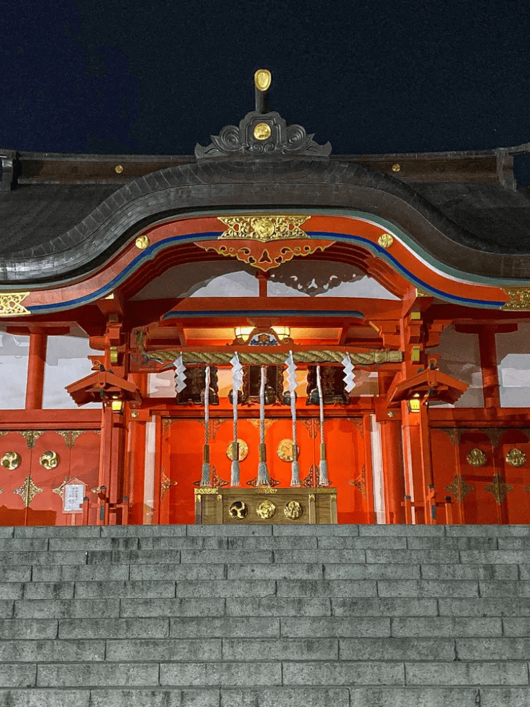 Colorful Japanese shrine with traditional architecture and decorative elements, evening scene.