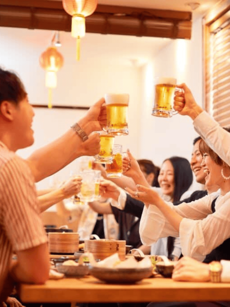 Cheerful group raising beer glasses in celebration at a restaurant or bar.
