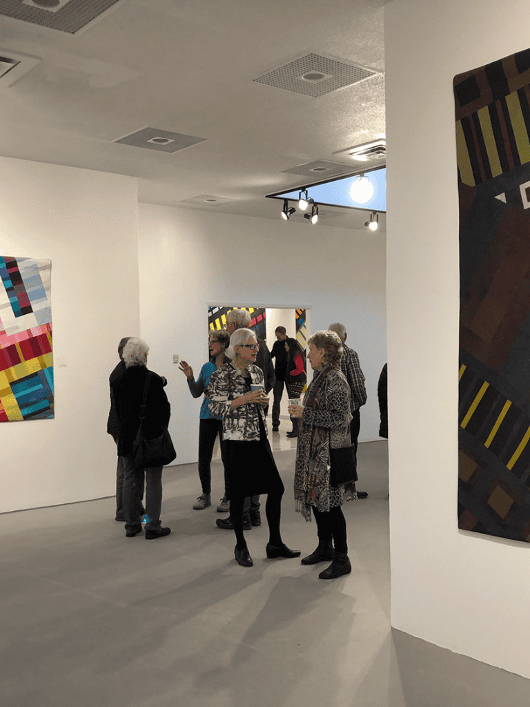 People viewing abstract art at QuestForDirections art exhibit.