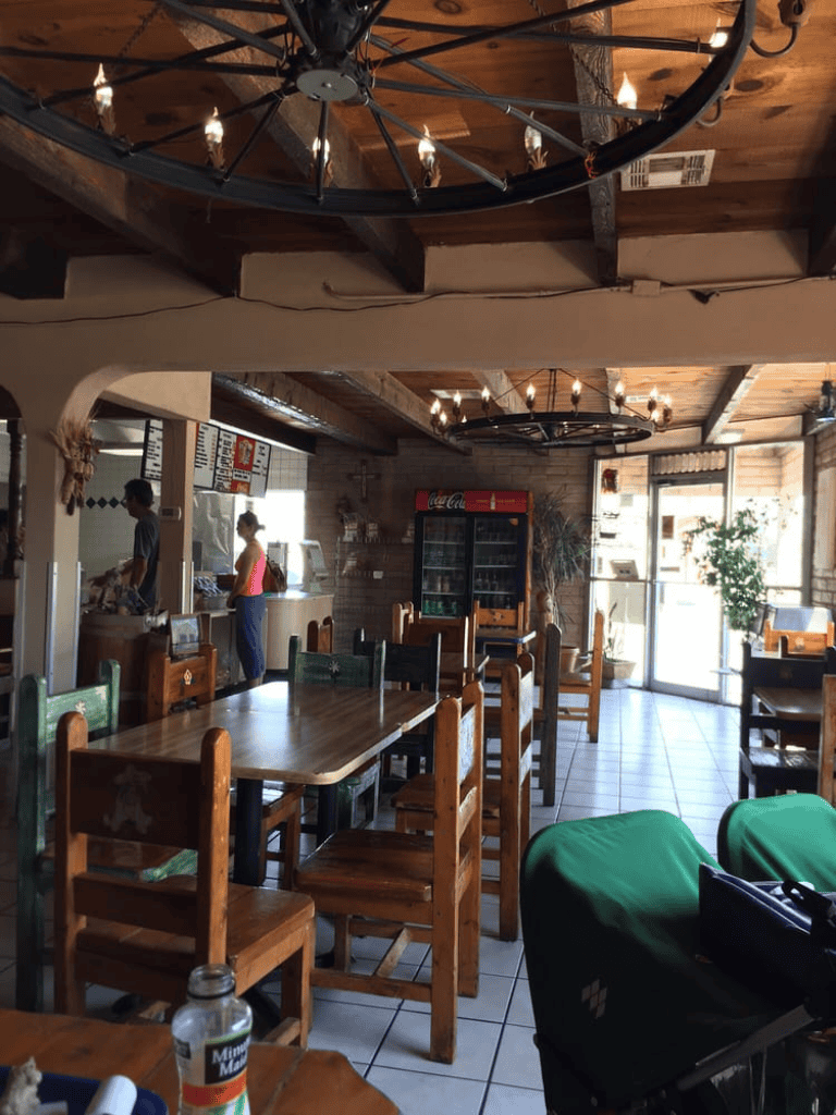 Charming rustic restaurant interior with wooden furniture and cozy lighting, ideal for dining and casual gatherings.