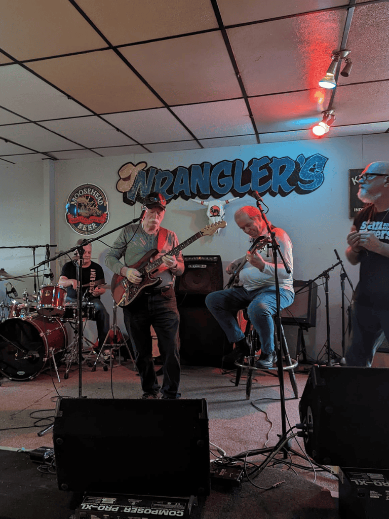 Live blues band playing guitars and drums at Wranglers bar and grill.
