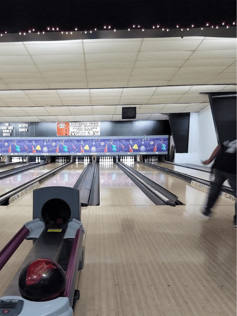1. Bowling alley lane with digital scoreboard and bowling ball ready for play.