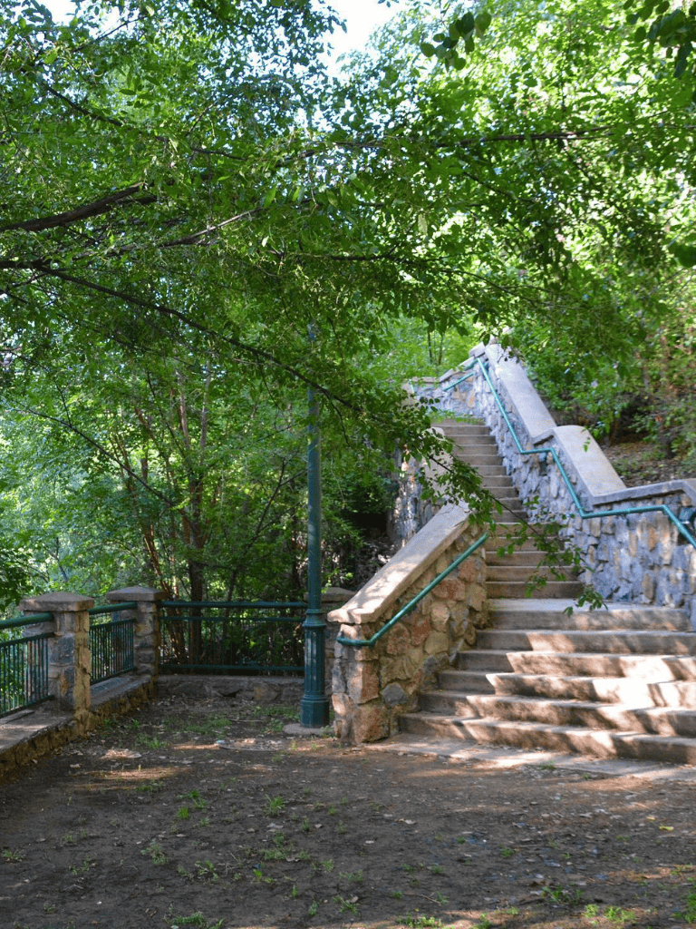 Lush green trees over stone staircase during daytime at QuestForDirections location.