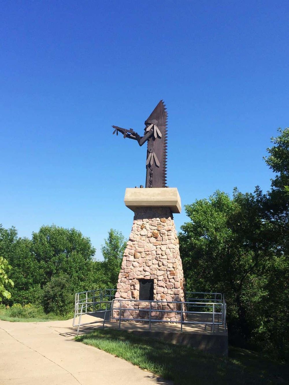 Metal eagle sculpture overlooking trees, public art installation at QuestForDirections site.