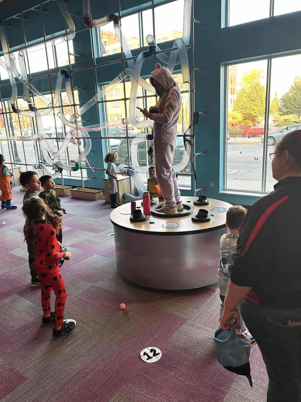 Imaginative indoor play area with children and adults, featuring interactive exhibits and innovative design.