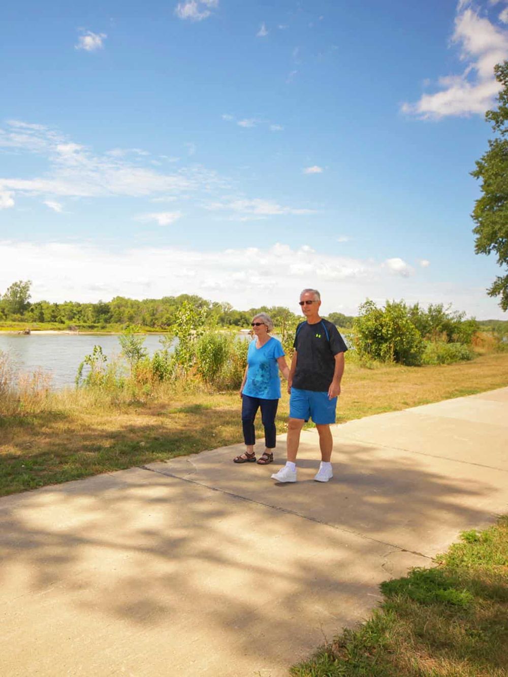 Relaxing walk by the river on a sunny day, enjoying outdoor activities and nature scenery.