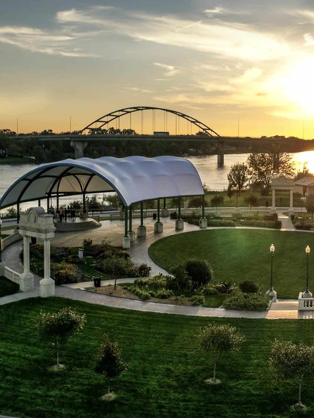 Scenic park with gazebo overlooking a river during sunset, highlighting outdoor spaces for community events and relaxation.