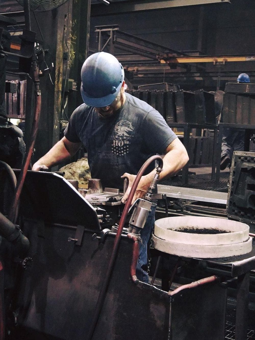 Industrial worker welding in factory industrial setting, safety gear, sparks, manufacturing, heavy machinery, skilled labor.