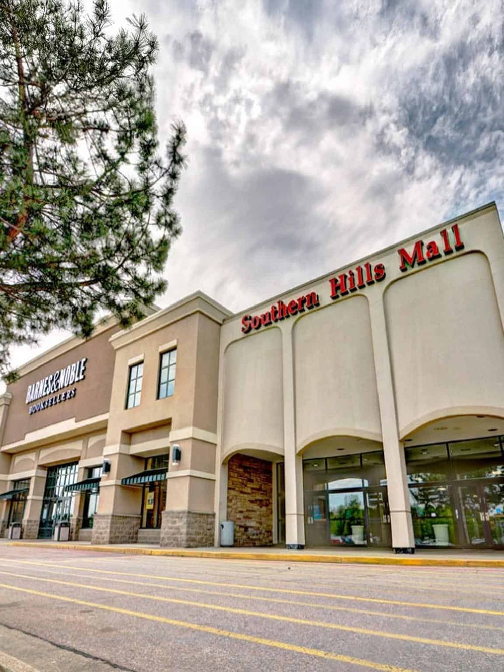 Bright shopping mall exterior with Southern Hills Mall sign and retail stores.